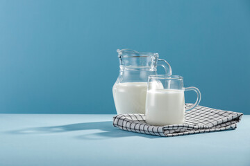 Fresh milk for breakfast in the sunshine on a blue background  - obrazy, fototapety, plakaty