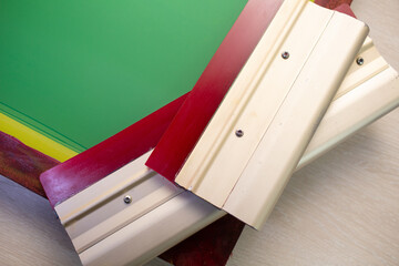 Serigraphy silk screen print process at clothes factory. Frame stencil and squeegee.