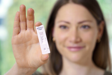 Lucky woman as a patient showing antigen self test card with negative result for Corona or Covid-19                    