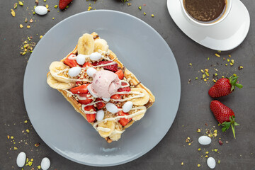 belgium waffles with strawberry and banana and a cup of coffee