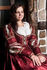 Pretty woman in red dress in retro baroque style