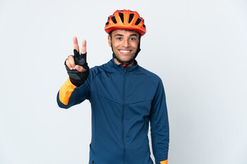 Young cyclist Brazilian man isolated on white background smiling and showing victory sign - obrazy, fototapety, plakaty