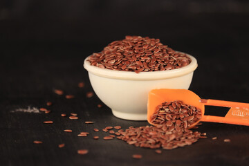 flex seeds in a white bowl with the black background,high fibre flex seed in bowl,Linum usitatissimum,Also known as Linseed