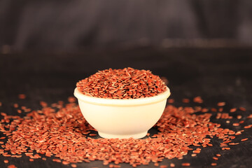 flex seeds in a white bowl with the black background,high fibre flex seed in bowl,Linum usitatissimum,Also known as Linseed