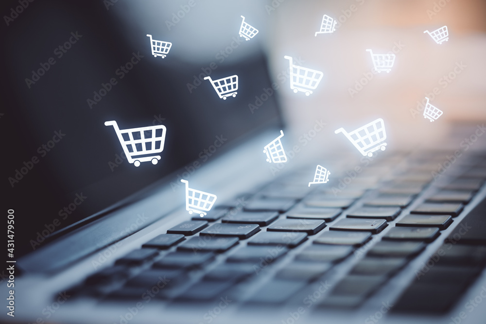 Poster multiple white shopping carts icons with a laptop in the background, closeup. online shopping and pu