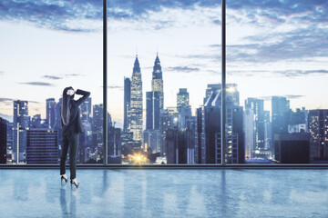 Fototapeta na wymiar Businesswoman standing thinking in an empty big office room with big windows and night city view. Real estate and future success concept