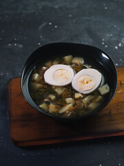 Russian traditional food, soup with sorrel, nettle, potatoes and egg