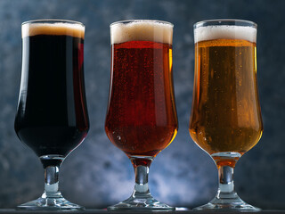 Three glasses of beer . Different beer styles, pilsner, lager, stout