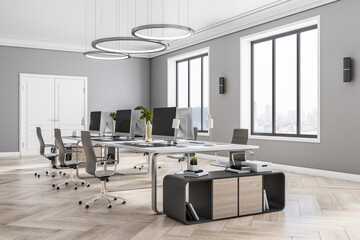 Sunny classic interior design of coworking office with wooden floor, stylish lamps from top, white door and big windows