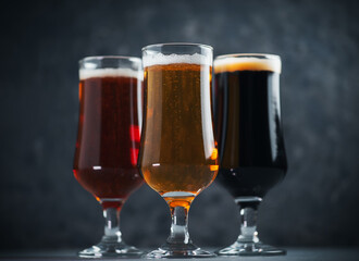Three glasses of beer . Different beer styles, pilsner, lager, stout