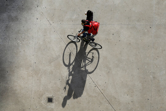 A delivery boy push his bike through Franklin Roosevelt square, downtown Sao Paulo, Brazil.