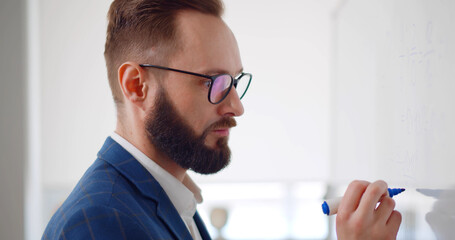 Handsome teacher drawing mathematical problem diagram on white board.