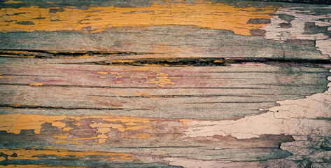 The texture of old yellow paint on a wooden board