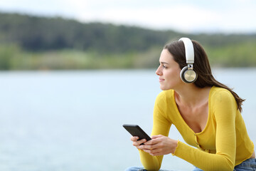 Fototapeta na wymiar Woman listening to music with headphones looking away