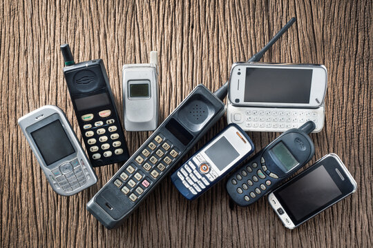 Pile of old and obsolete mobile phone or cell phone on old wood background