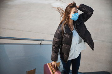 Young female traveler on windy day in the airport