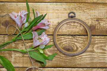 Bright white and pink flowers Alstroemeria and small frames and browm wooden textured background close-up
