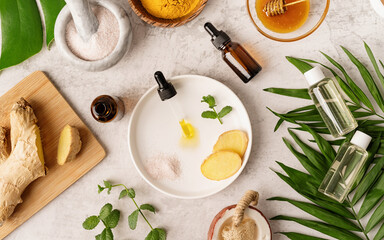 Natural cosmetics ingredients on the table. Oil, ginger, mint, Himalayan salt and golden honey in jar.