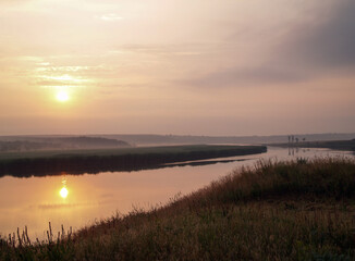 Fototapeta na wymiar Rising sun above misty river.