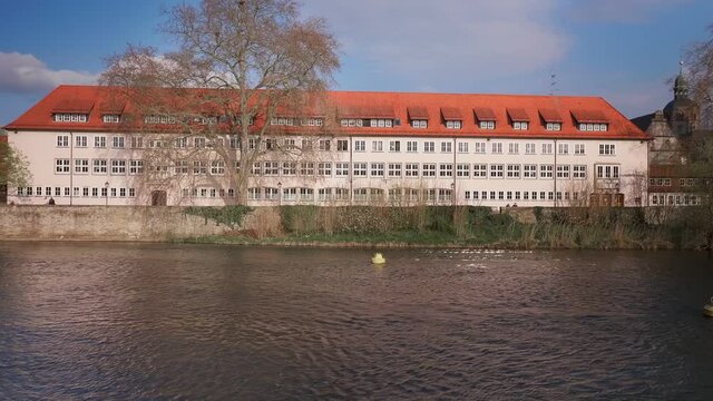 A flowing Weser River in front of a building in Hameln, Germany in 4K