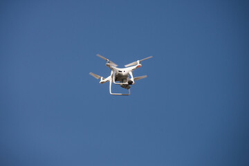 closeup of white quadcopter drone for video appllcation in outdoor on blue sky background
