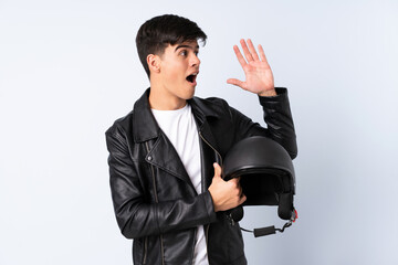 Man with a motorcycle helmet over isolated blue background shouting with mouth wide open