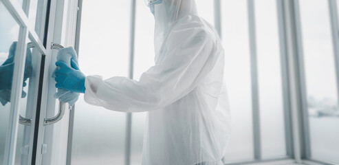 Man in virus protective suite and mask cleaning covid19 infected area, Virus disinfection concept