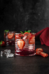 bar magazine concept. cocktail, drink with ice and fresh strawberries. with mint leaves. low key, dark mood