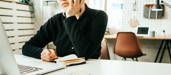 Sad woman working at white office with laptop