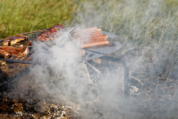 smoke blowing over grilled meat, outdoor bbq