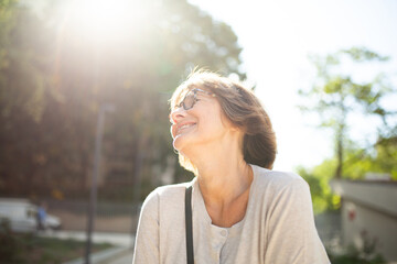 Close up older woman with eyeglasses laughing outside