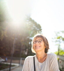 Close up smiling older woman with eyeglasses outside