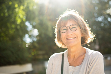 Close up smiling older woman outside with glasses