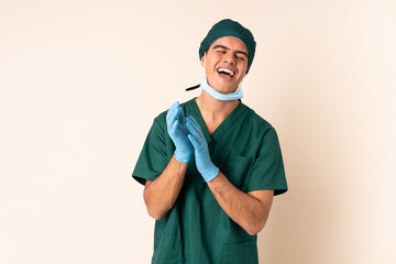 Surgeon man in blue uniform over isolated background laughing