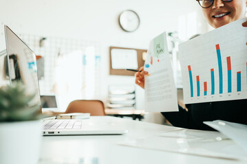 Woman working alone with stock market using laptop, analyzing trading data