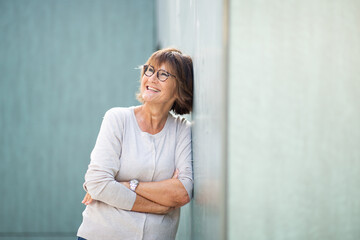 attractive older woman leaning against wall and laughing