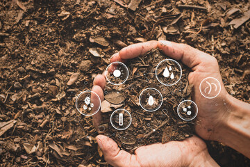 Rich loam in the hands of a man and a technology icon and elements in the soil around it.