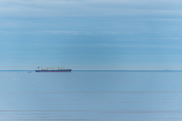 Cargo Ship on a Quiet Baltic Sea near a Lighthouse Island with Birds
