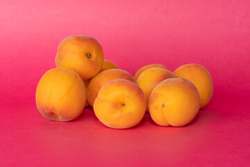 Pile of small, fresh, ripe, juicy, peaches on a colourful background, stock picture.