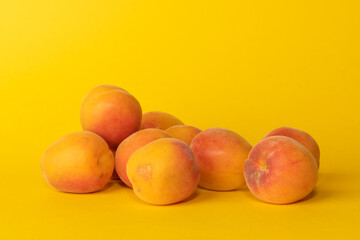 Pile of small, fresh, ripe, juicy, peaches on a colourful background, stock picture.