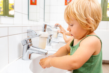 Child in kindergarten washing her hands
