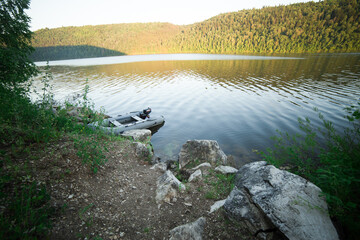 An inflatable rubber boat is moored to the shore. Summer holiday painting