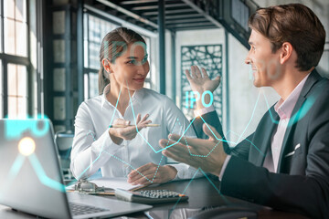 Fototapeta premium Businessman and businesswoman in formal wear working together to optimize IPO strategy at corporate fund. Financial chart hologram over office background with panoramic windows