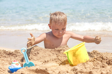boy playing in the sand on the beach