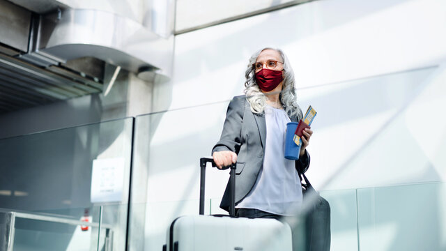 Senior woman in airport lounge, coronavirus, travel and new normal.
