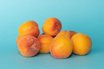 Pile of small, fresh, ripe, juicy, peaches on a colourful background, stock picture.
