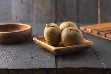 Kiwi fruit in wooden bowl and wooden background