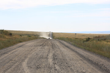 Van on the dry road in the steppe 