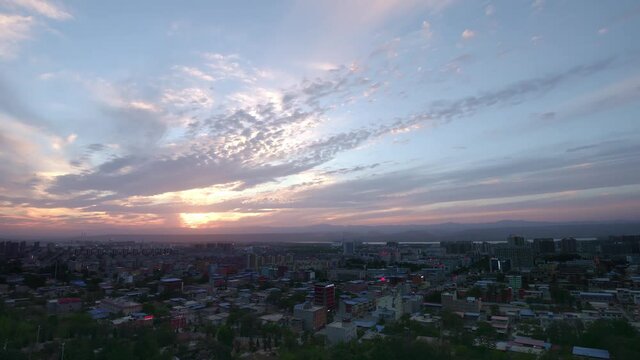Time-lapse of dark clouds moving over the city at sunset