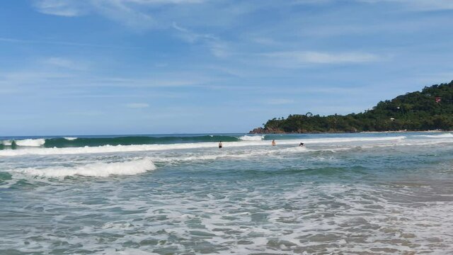 Dream beaches and tropical paradises. Waves of blue ocean on sandy beach. Ubatuba, Brazil.